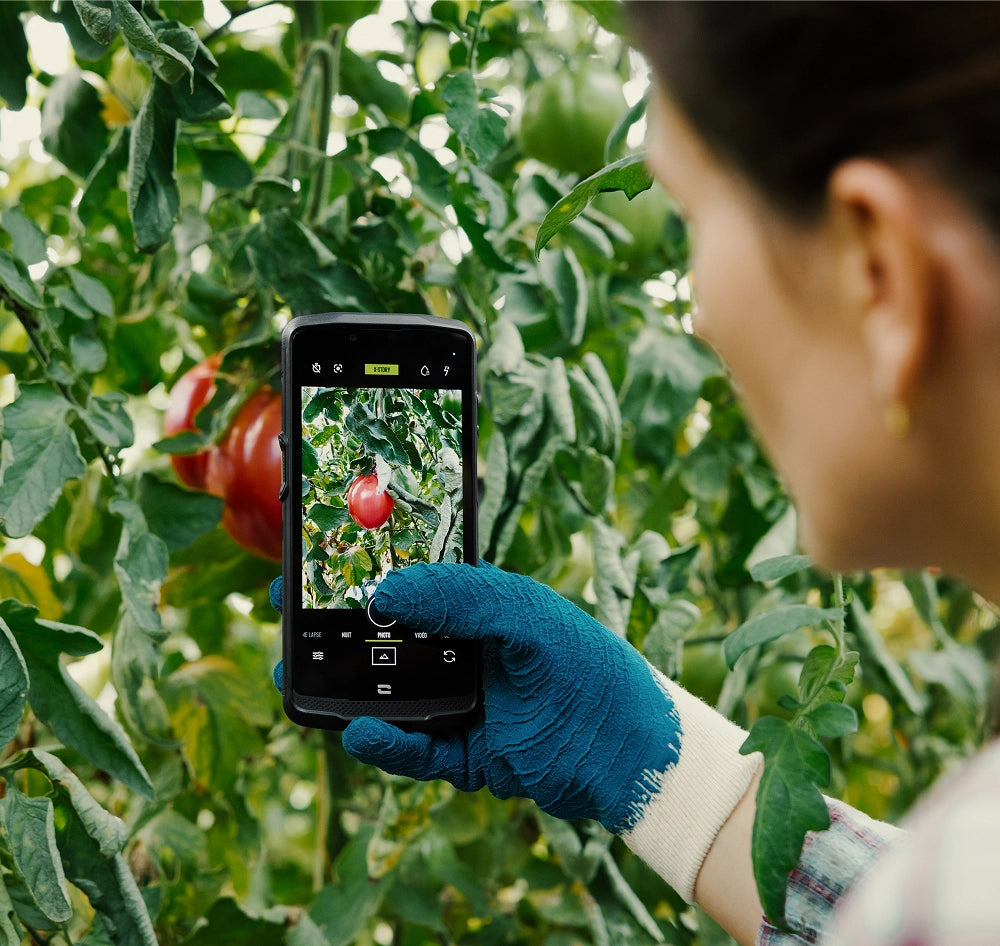 Professionnel de l’agriculture utilisant un terminal Crosscall avec des gants
